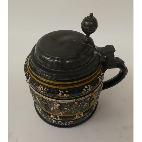 167 - A Bavarian reproduction of a stoneware tankard with a hinged, pewter lid and handle, decorated with ... 