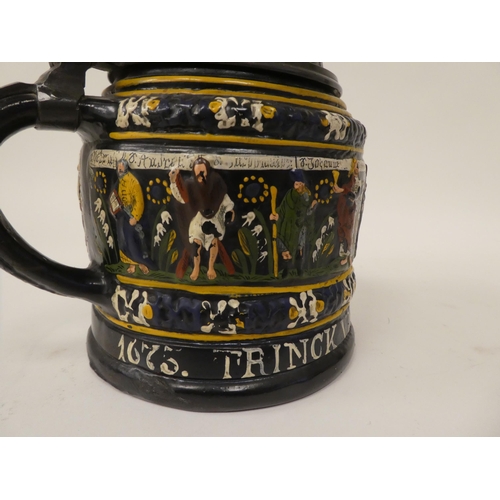 167 - A Bavarian reproduction of a stoneware tankard with a hinged, pewter lid and handle, decorated with ... 