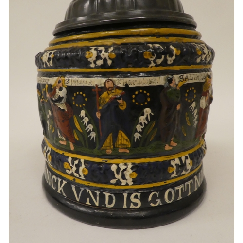 167 - A Bavarian reproduction of a stoneware tankard with a hinged, pewter lid and handle, decorated with ... 