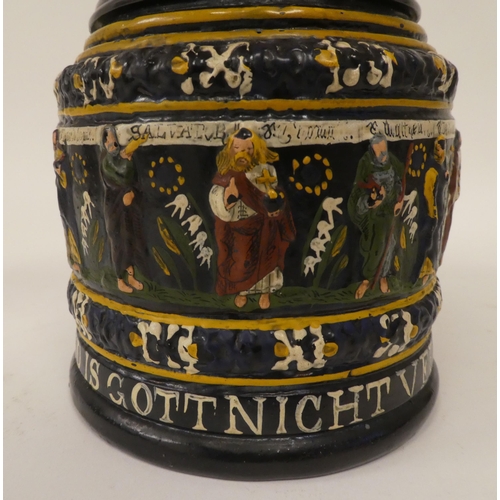 167 - A Bavarian reproduction of a stoneware tankard with a hinged, pewter lid and handle, decorated with ... 