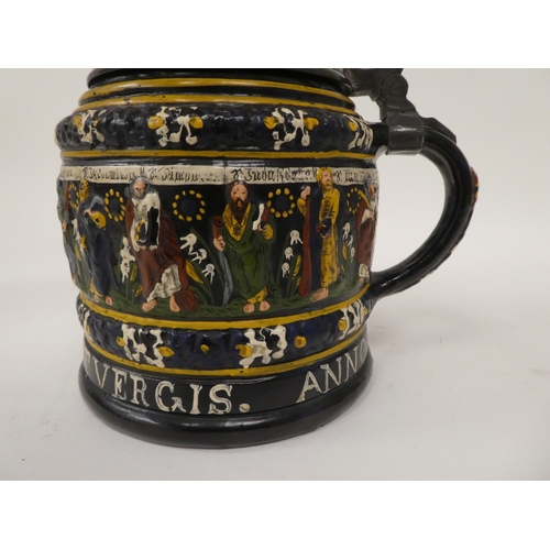 167 - A Bavarian reproduction of a stoneware tankard with a hinged, pewter lid and handle, decorated with ... 