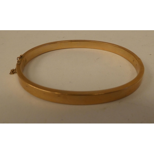 196 - A gold coloured metal hinged bangle  stamped 15ct