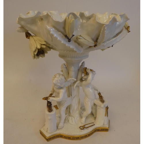 21 - A late 19thC Moore white pottery and part gilded table centrepiece, featuring a floral encrusted bow... 