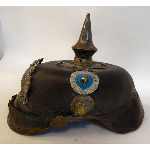 23 - A German pickelhaube with a chinstrap, white metal and brass fittings(Please Note: this lot is subje... 