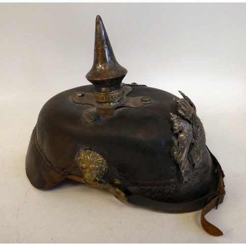 23 - A German pickelhaube with a chinstrap, white metal and brass fittings(Please Note: this lot is subje... 