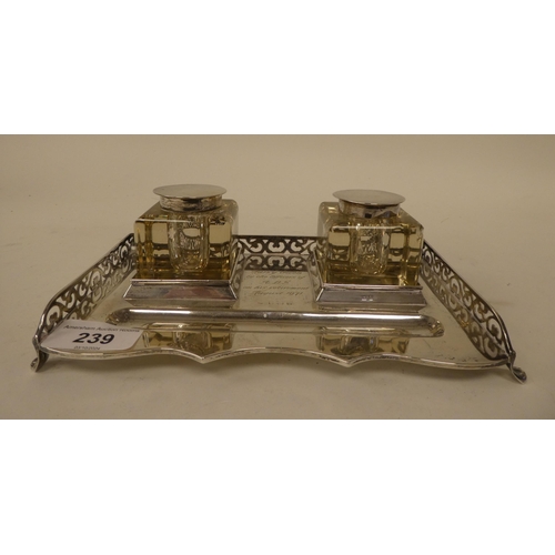 239 - A silver standish, the galleried tray with a pen channel and a pair of cast glass and silver lidded ... 