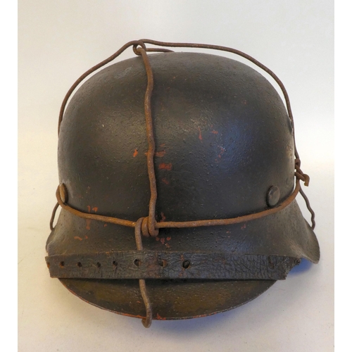 24 - A German Luftwaffe steel helmet with a decal, chinstrap, hide liner and applied wire provision for c... 