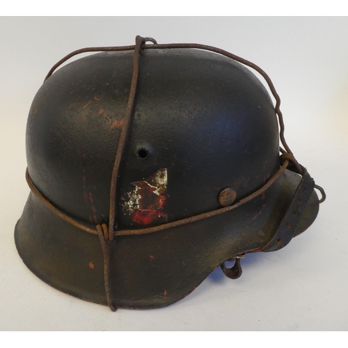 24 - A German Luftwaffe steel helmet with a decal, chinstrap, hide liner and applied wire provision for c... 