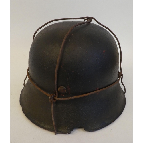 24 - A German Luftwaffe steel helmet with a decal, chinstrap, hide liner and applied wire provision for c... 