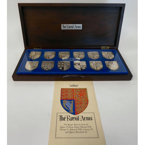 56 - A series of twelve silver coloured metal depictions of The Royal Arms, as borne by Queen Victoria th... 