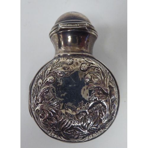 60 - A 19thC silver and parcel gilt, folding perfume bottle holder with embossed decoration, hinged acces... 