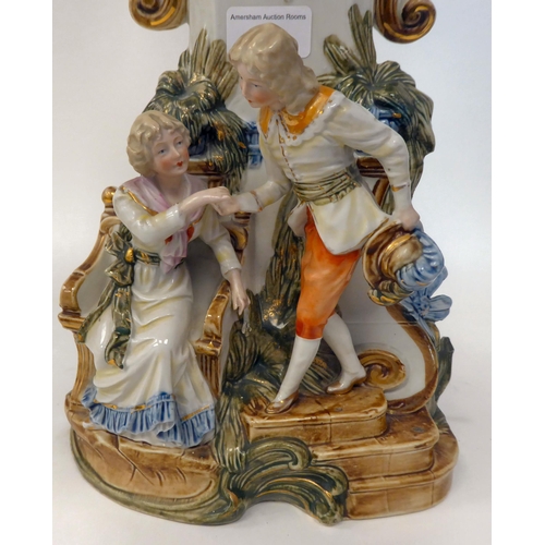 64 - A Victorian style novelty mantel timepiece, the china case featuring a couple below the floral decor... 