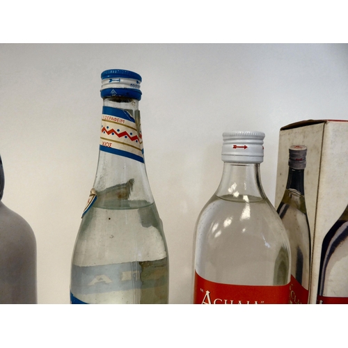 83 - Three bottles of Ouzo, viz. Achaia Claus, Amanapine and another in a ceramic flask