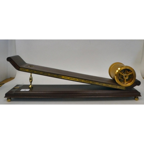 9 - A modern reproduction of 'The Inclined Plane Clock' featuring a gilt metal drum cased timepiece, on ... 