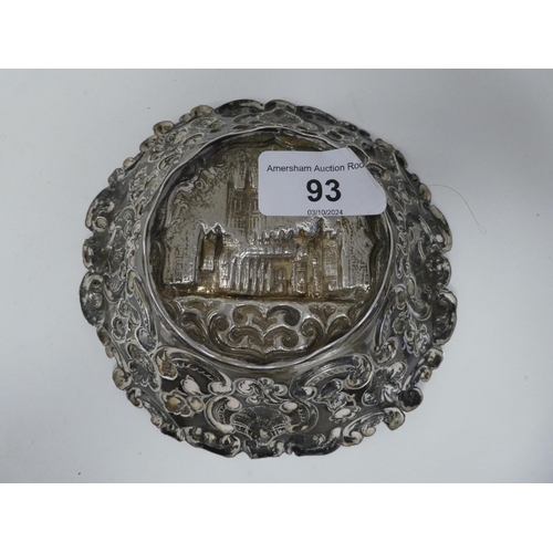 93 - A silver dish, featuring an embossed elevation of a church, the borders depicting sea scrolls, shell... 