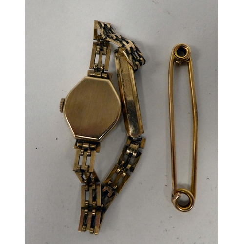 198 - A gold coloured metal scarf pin  stamped 15ct; and a lady's Sekonda 9ct gold cased wristwatch