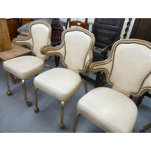 178 - A set of four modern Gasser metal framed and cream vinyl upholstered dining chairs, on casters