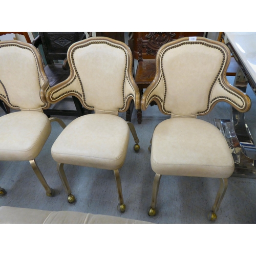 178 - A set of four modern Gasser metal framed and cream vinyl upholstered dining chairs, on casters