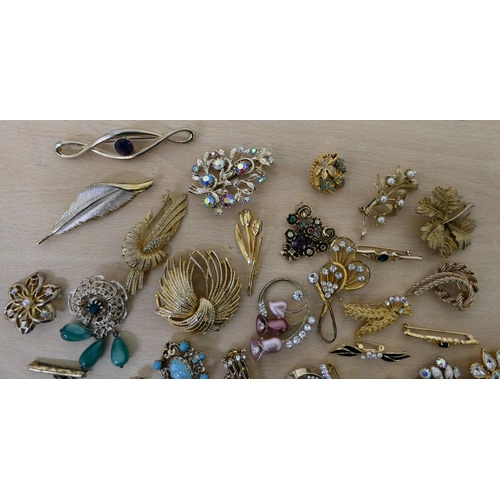 21 - Costume jewellery, mostly brooches: to include a floral example, set with simulated pearls