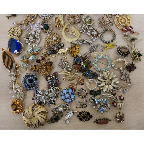 31 - Costume jewellery, mostly brooches: to include an example set with dark red stones