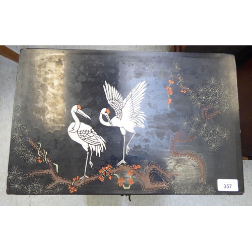 357 - A modern Chinese inspired black lacquered and overpainted, three drawer bedside chest, raised on blo... 