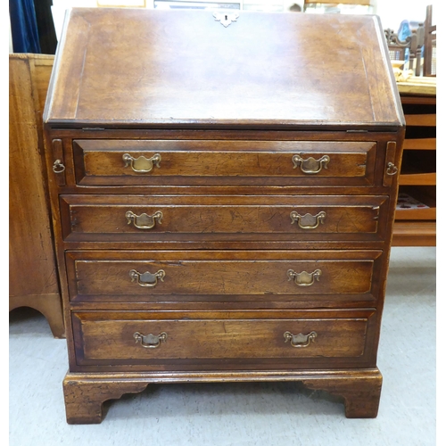 361 - A modern Georgian design oak bureau with a fall flap, over four drawers, raised on bracket feet ... 