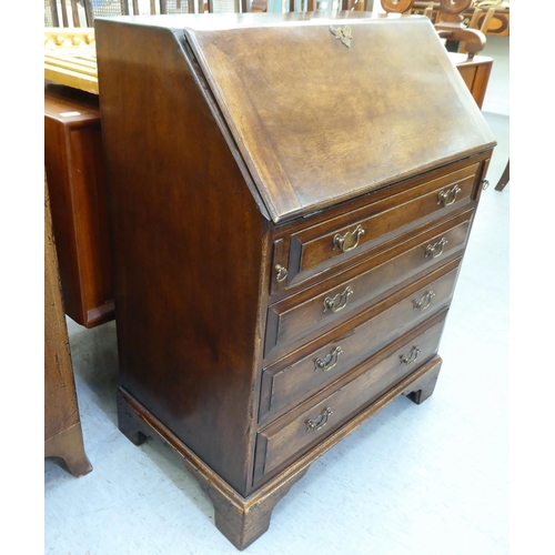 361 - A modern Georgian design oak bureau with a fall flap, over four drawers, raised on bracket feet ... 