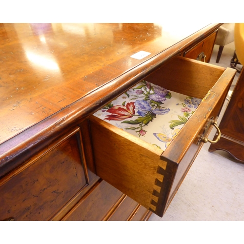 362 - A modern walnut dressing chest with five short/two long drawers, raised on bracket feet  35