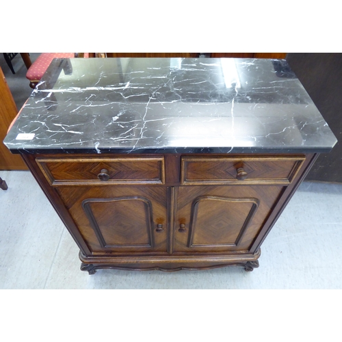 364 - A late 19thC kingswood side cabinet with a marble top, over two drawers and two doors, raised on cab... 