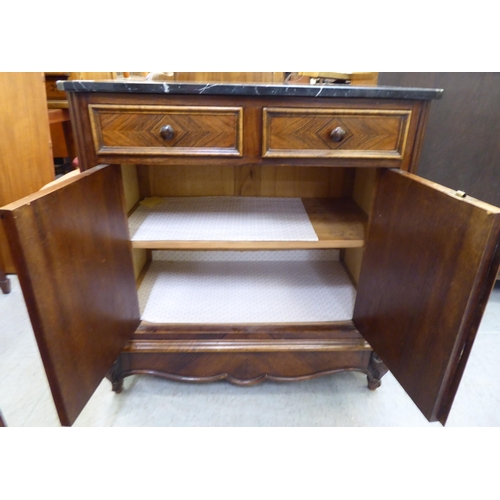 364 - A late 19thC kingswood side cabinet with a marble top, over two drawers and two doors, raised on cab... 