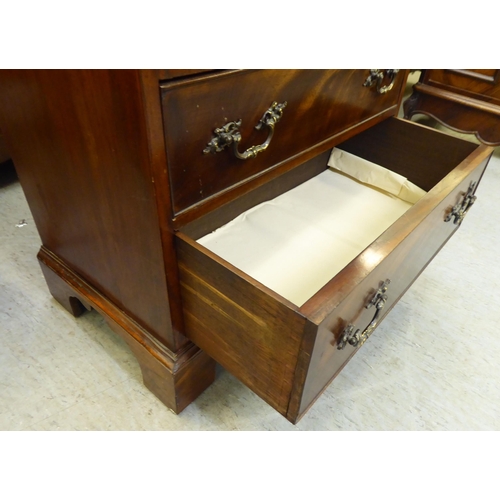 366 - An early 20thC mahogany bachelor chest with a foldover top and four long drawers, raised on bracket ... 