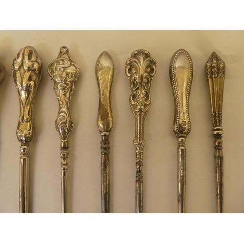 49 - A quantity of steel and decoratively embossed, silver handled, Edwardian/Victorian button hooks ... 