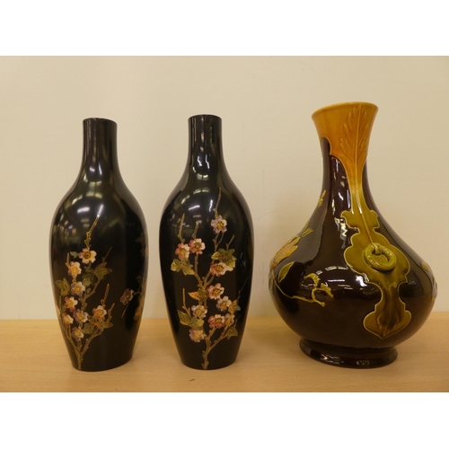 53 - Bretby pottery, viz. a pair of opaque black glazed, floral and gilt painted vases, featuring hedgero... 