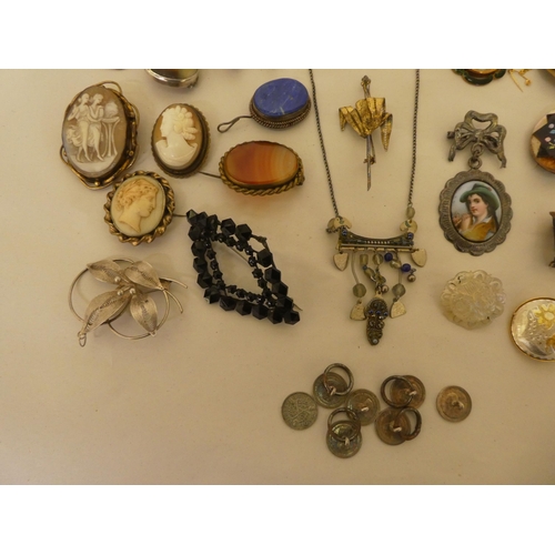 54 - Costume jewellery: to include a silver mounted bird's claw brooch; and a filigree worked, white meta... 