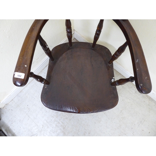 102 - An early 20thC and later overpainted oak framed a captain's desk chair, the solid seat raised on rin... 