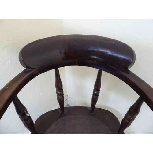 102 - An early 20thC and later overpainted oak framed a captain's desk chair, the solid seat raised on rin... 