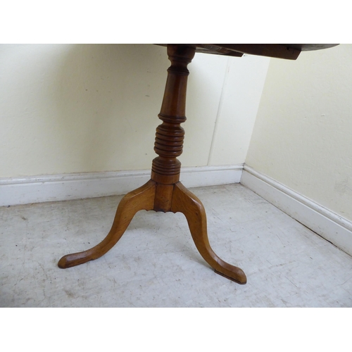 124 - A 19thC oak tip-top table, raised on a ring turned column and tripod base  27