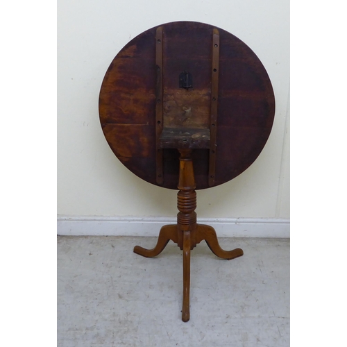 124 - A 19thC oak tip-top table, raised on a ring turned column and tripod base  27