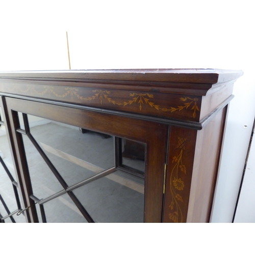 133 - An Edwardian string inlaid and marquetry mahogany, two door glazed bookcase, raised on tapered legs ... 