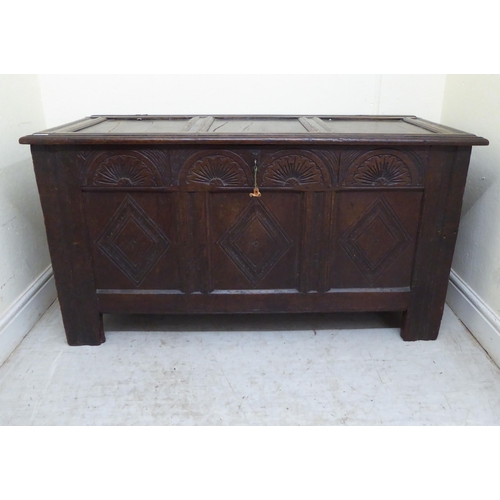 134 - A late 18thC panelled oak coffer with straight sides and a hinged lid, raised on square legs  2... 