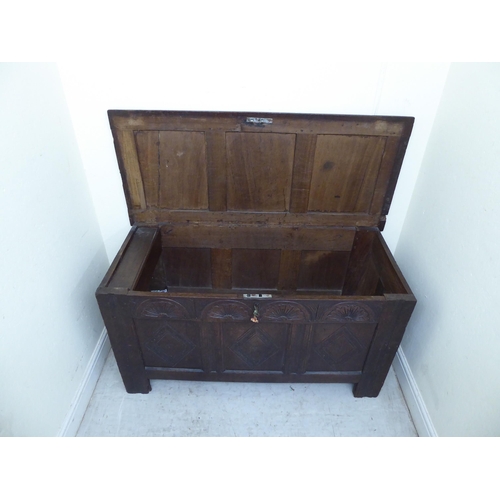 134 - A late 18thC panelled oak coffer with straight sides and a hinged lid, raised on square legs  2... 