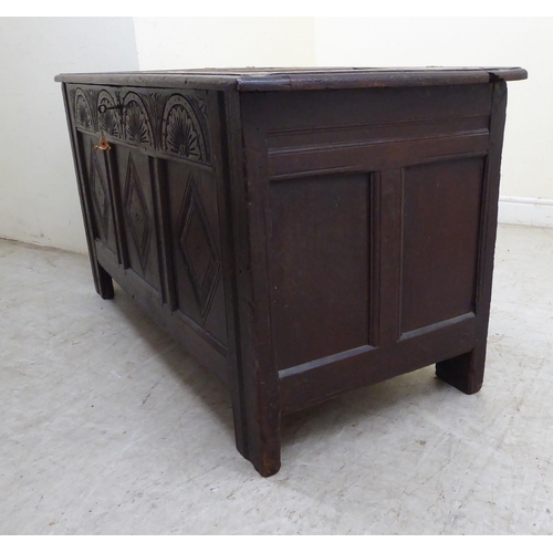 134 - A late 18thC panelled oak coffer with straight sides and a hinged lid, raised on square legs  2... 