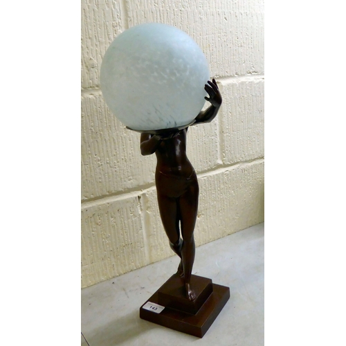 143 - A modern reproduction of an Art Deco inspired bronze table lamp, fashioned as a nude, holding a sphe... 