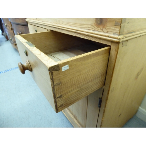 195 - A modern students desk, the sloped hinged lid, over two short drawers and two doors, raised on bun f... 