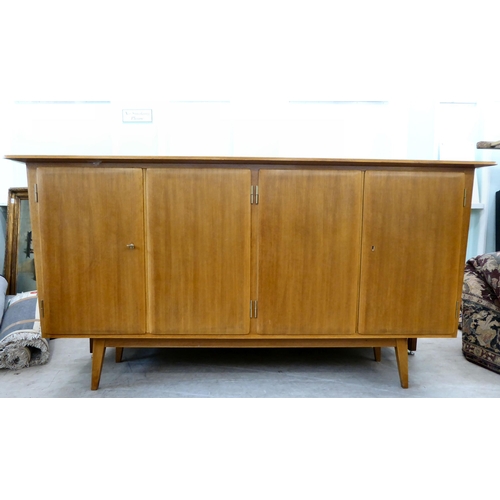 369 - A 1960/70s Produit Suisse Schweizerjabrikat teak sideboard with four doors, enclosing open shelves, ... 