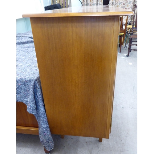 369 - A 1960/70s Produit Suisse Schweizerjabrikat teak sideboard with four doors, enclosing open shelves, ... 