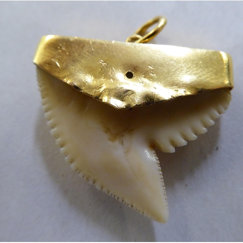 373 - A yellow metal pendant, on a ring, set with a shark tooth