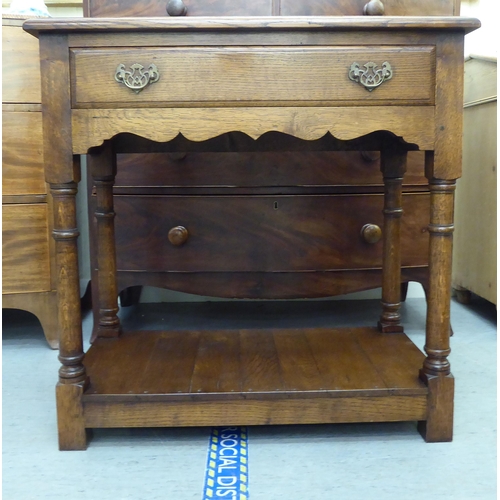 374 - A modern oak side table with a frieze drawer, raised on turned legs, united by an undershelf and blo... 