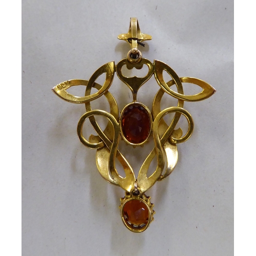 376 - A 9ct gold Art Nouveau design pendant, claw set with two citrine coloured stones