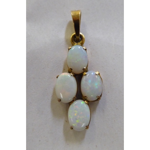 378 - A yellow metal pendant, set with four opals